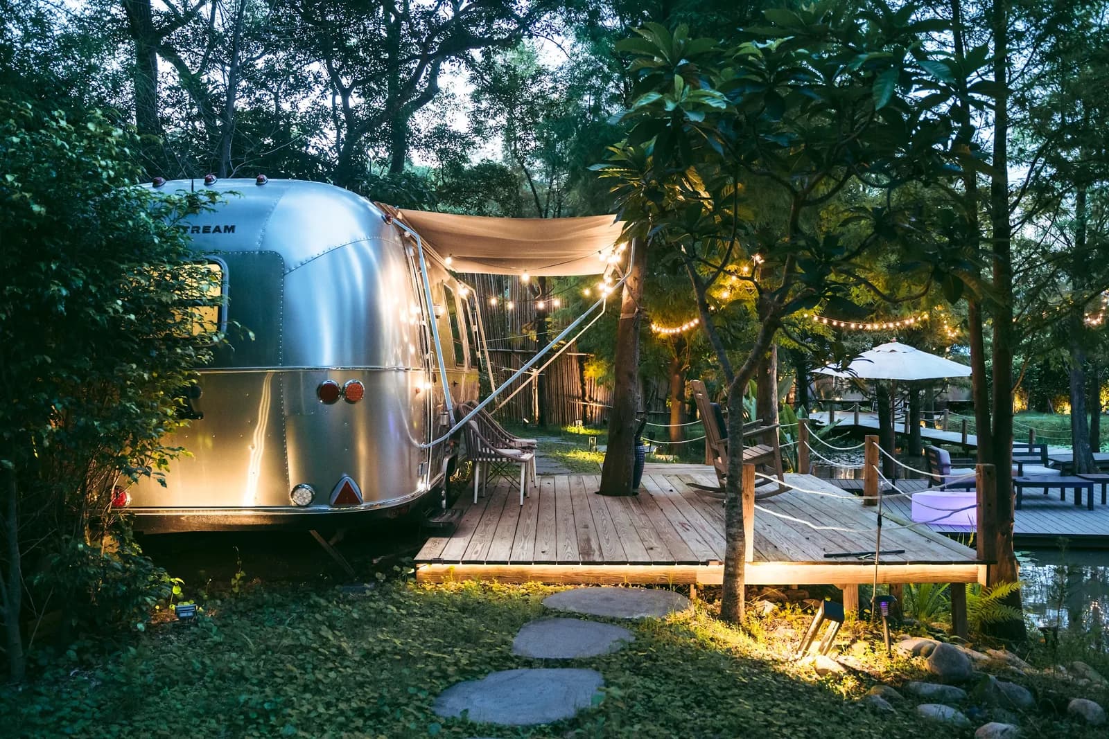 山林裡亮燈的 Airstream 露營車與戶外平台